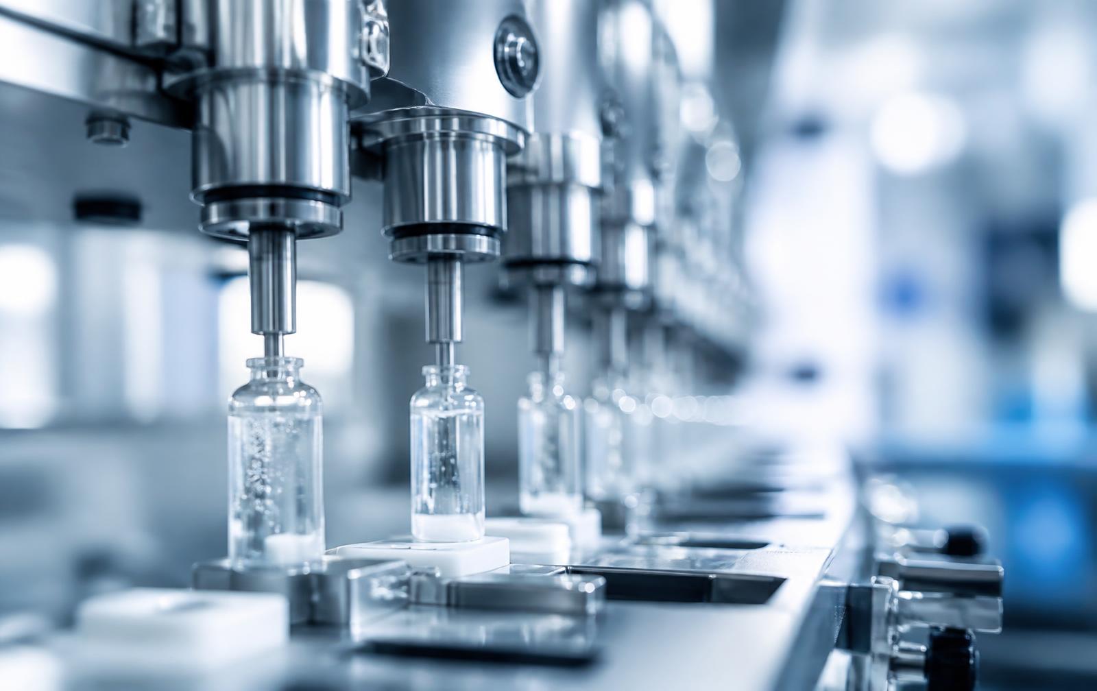 Detalle de equipo de llenado de acero inoxidable en una línea de producción